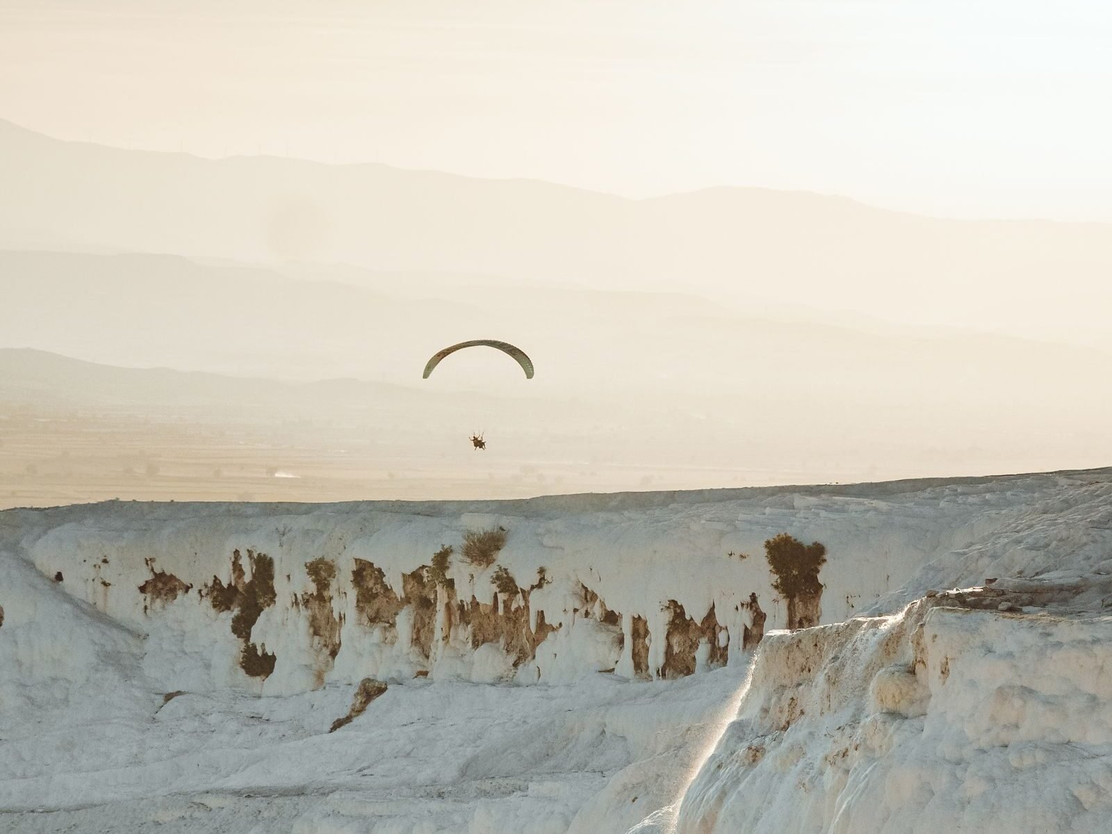Pamukkale paragliding over the white terraces at sunset